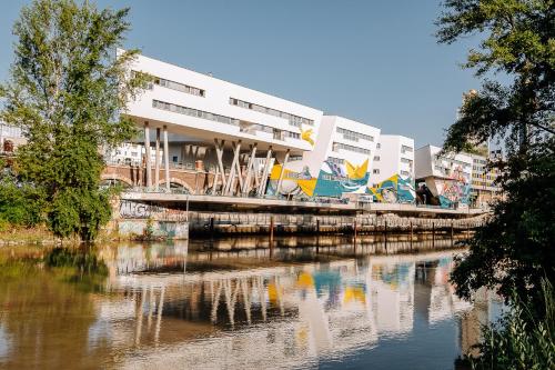 a building next to a river in front of a building at URBAN ISLAND I Riverside Apartments in Vienna
