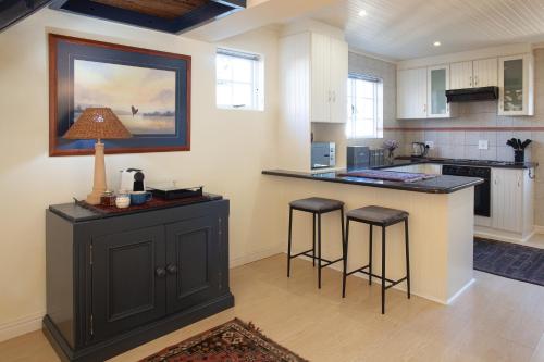 a kitchen with a counter and two bar stools at Sunflower Villa in Franschhoek in Franschhoek