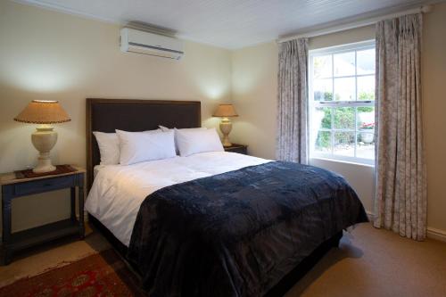 a bedroom with a large bed and a window at Sunflower Villa in Franschhoek in Franschhoek