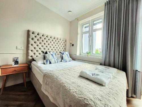 a bedroom with a large bed with a window at Villa Blue Mare I Gastro Wałówka Ciepłe napoje w cenie pobytu in Ustronie Morskie