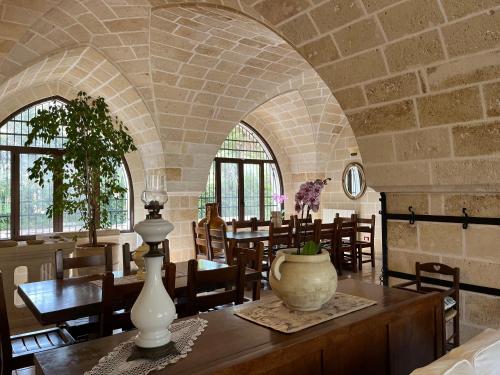 Masseria La Camardia في سافا: غرفة مع طاولة عليها مزهرية