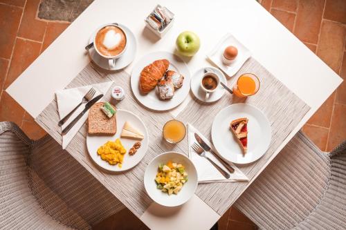 a table with plates of food and cups of coffee at Nikis Resort in Gubbio
