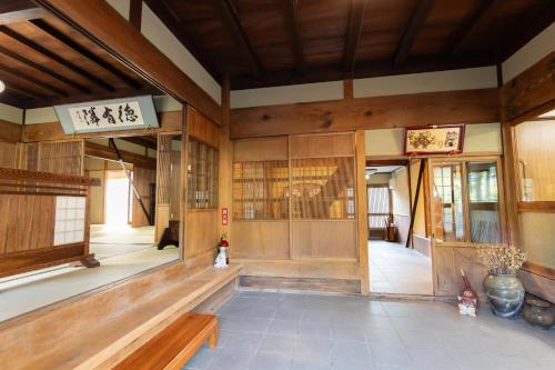 Habitación con paredes y ventanas de madera en un edificio en 大正の宿　浪漫邸, en Kani