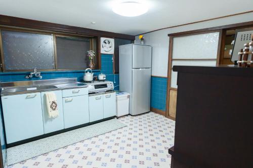 a kitchen with white appliances and blue walls at 大正の宿　浪漫邸 in Kani