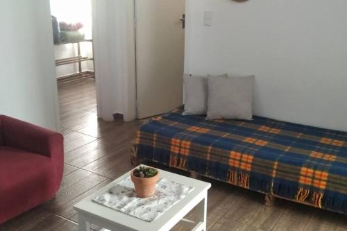 um quarto com uma cama e uma mesa com uma planta em Casa 346 em Ponta Grossa