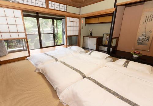 a group of white pillows in a room with windows at 大正の宿　浪漫邸 in Kani