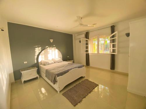 um quarto com uma cama branca e uma janela em Anwar GuestHouse em Luxor
