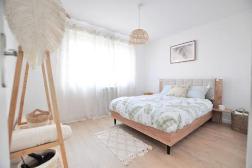 une chambre blanche avec un lit et une grande fenêtre dans l'établissement *L'écrin de Ronsard*Plage & Centre-Ville, à Dunkerque