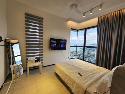 a bedroom with a bed and a flat screen tv at Executive Premium Urban Suites - Jelutong in Jelutong