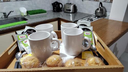 una caja llena de tazas y magdalenas en una cocina en Miri House en Bahía Blanca