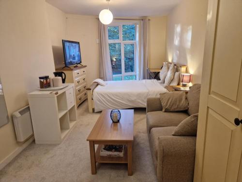 a small living room with a bed and a couch at West Beck House in Darlington