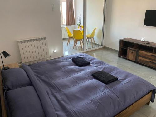 um quarto com uma cama azul, uma mesa e cadeiras em Casa Cojocaru em Turnu Măgurele