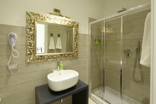 a bathroom with a sink and a shower with a mirror at Affittacamere Arosio in Monza