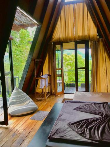 a room with a bed in a tent with windows at The Backyard Balangoda in Balangoda