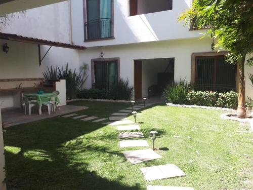 a backyard with a table and a green lawn at ORQUIDEA in Irapuato