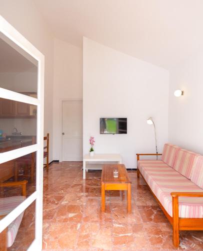 a living room with a couch and a table at Bungalows Las Almenas in Maspalomas