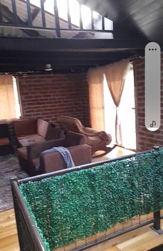 a living room with a couch and a green hedge at MIRADOR MAMÁ NATY Y SUS NEGUITOS in Chambo