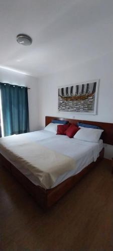 - une chambre avec un grand lit blanc et des oreillers rouges dans l'établissement Ca’ Tina, à Santa Maria