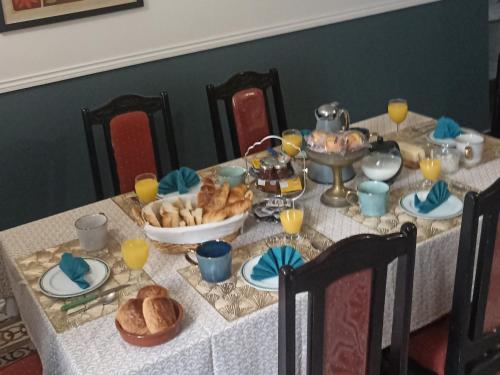 una mesa con un mantel blanco con pan y un tazón de comida en Mas des 2 paons, en Villedaigne
