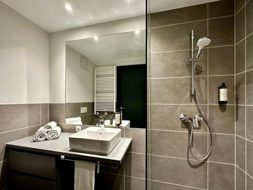 a bathroom with a sink and a shower at Apartimo München-Unterhaching in Unterhaching