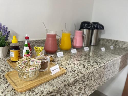 a counter with a cutting board with condiments on it at Hotel 7 Quedas in Guaíra