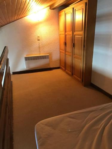 une pièce vide avec un lit et une armoire dans l'établissement Studio Duplex Pra Loup 1500, à Uvernet
