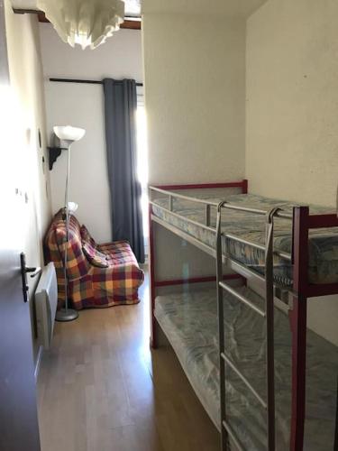Cette chambre comprend 2 lits superposés et une chaise. dans l'établissement Studio Duplex Pra Loup 1500, à Uvernet