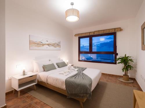 1 dormitorio con cama y ventana en Giraud II - Secluded beachfront duplex, en Santa María de Guía de Gran Canaria