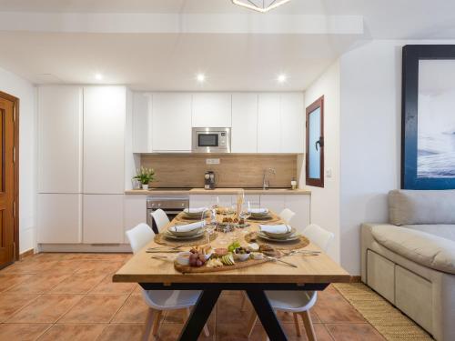 a kitchen and dining room with a table and a couch at Giraud II - Beachfront - Pool - 46 m2 Terrace in Santa Maria de Guia de Gran Canaria
