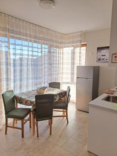 uma cozinha com uma mesa e cadeiras e um frigorífico em Megi Apartments, Nesebar sity em Nesebar