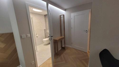 a bathroom with a toilet and a glass door at Hotel & Restauracja Wróblewscy in Karniewo