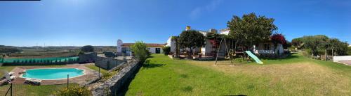 a house with a large yard with a swimming pool at Casal Serrano Charme e Tranquilidade in Reguengo Grande