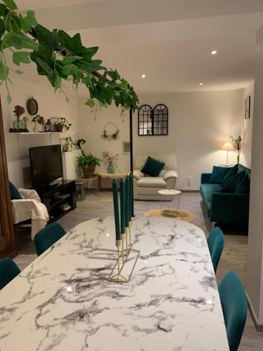 - un salon avec une table et des chaises vertes dans l'établissement Appartement Rez de chaussé maison, à Morbier