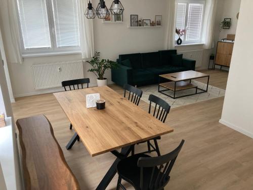 uma sala de estar com uma mesa de madeira e cadeiras em Apartmán 696 Pod Ještědem em Liberec