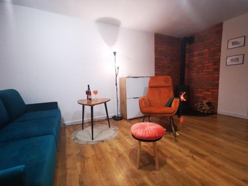 uma sala de estar com um sofá, uma cadeira e uma mesa em Apartament Chełmsko Śląskie em Chełmsko Śląskie