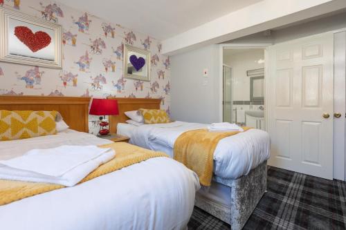 a bedroom with two beds and a mirror at Adelaide Lodge - Town Centre - Opposite Winter Gardens in Blackpool