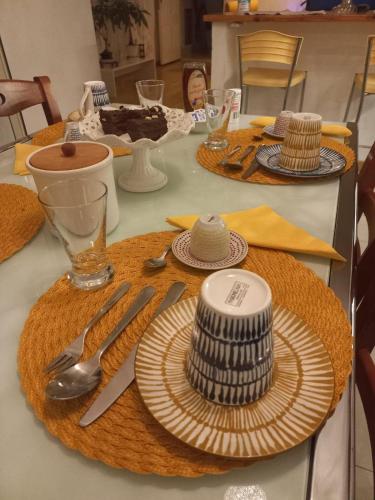 einen Tisch mit Tellern und Besteck darüber in der Unterkunft A un passo da... B&B in Elmas