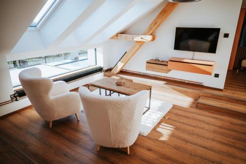 a living room with a table and chairs and a tv at Galerie mlýn Žeraviny in Žeraviny