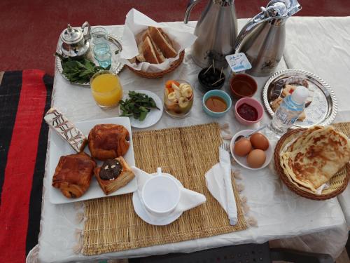 布曼恩的住宿－Hôtel Riad Atlas Dades，餐桌上摆放着早餐食品和橙汁