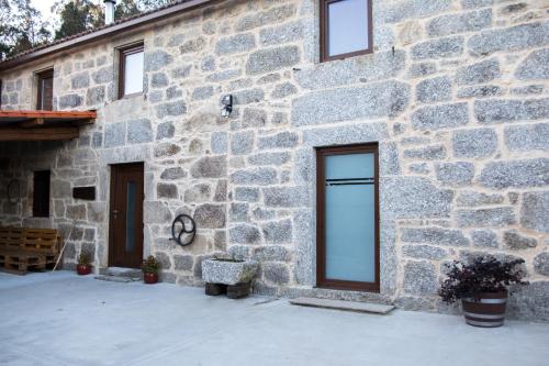 un edificio de piedra con una ventana en el lateral. en A CASA DA MOREIRA - Casa rural en Ponte Maceira, en A Coruña