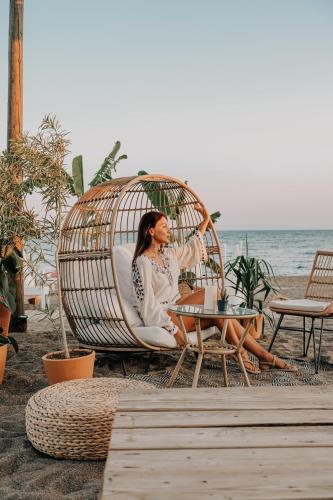 a woman sitting in a chair on the beach at RAW BEACH HOTEL in Antalya