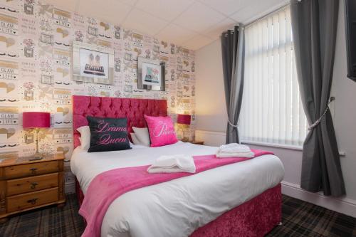 a bedroom with a large bed with a pink headboard at Adelaide Lodge - Town Centre - Opposite Winter Gardens in Blackpool