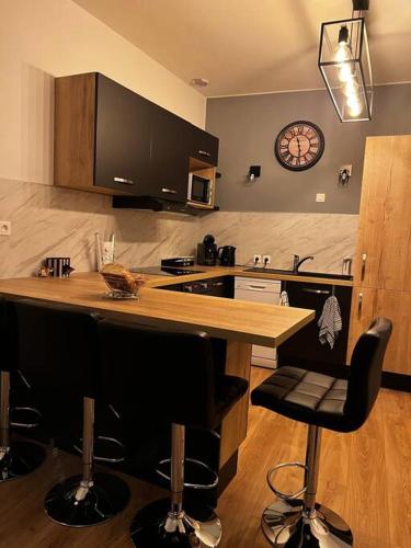 une cuisine avec un comptoir et une horloge au mur dans l'établissement T2 PARFAITEMENT SITUÉ AU PIED DE LA CATHÉDRALE, à Périgueux