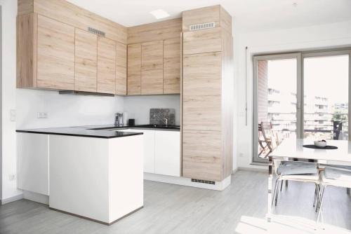 uma cozinha com armários brancos, uma mesa e uma janela em Lovely Modern 1 BR apartment em Luxemburgo