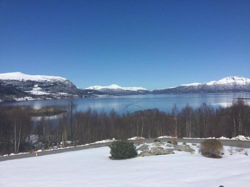 a view of a lake with snow covered mountains at Sivert´s kontorhotell in Tomrefjord