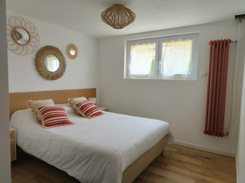 Un dormitorio con una cama con almohadas rojas y una ventana en Le FAYA, en Pouzauges
