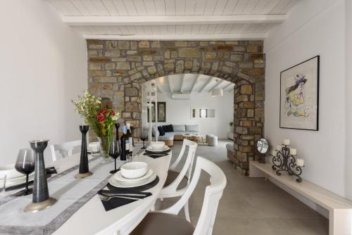a dining room with a white table and chairs at Villa Isterni Paros in Isterni