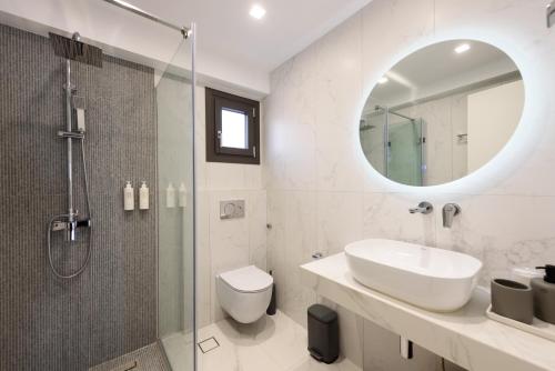a bathroom with a shower and a sink and a mirror at Villa Isterni Paros in Isterni