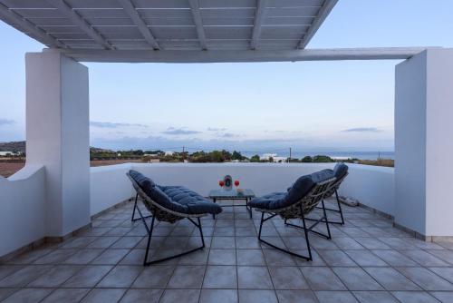 a patio with two chairs and a table on a balcony at Villa Isterni Paros in Isterni