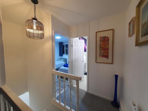 a hallway with a staircase and a chandelier at Limehouse Guest House Central East London in London